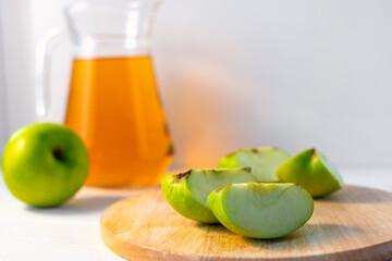 Apples and decanter of juice on white table. Copy space. 