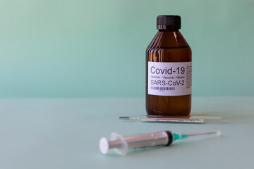 Covid-19 vaccine with descartable syringe and glass thermometer. Concept of cure for coronavirus...