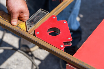 Working auxiliary tools in the hands of a worker welder. Using a magnetic welding angle in work to...