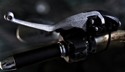Close up of vintage motorcycle gas handlebar with blurred backdrop.