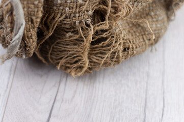 Burlap texture on old wooden table with sack cloth in dark interior with copy space.
