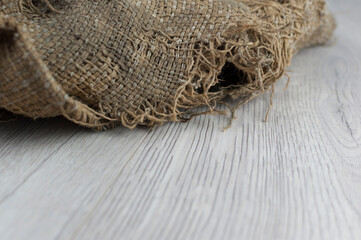 Burlap texture on old wooden table with sack cloth in dark interior with copy space.