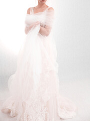 Fototapeta na wymiar Girl in a wedding dress on a light background