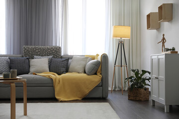 Elegant living room with comfortable sofa near window. Interior design
