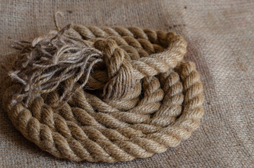 Thick natural rope wound in a reel on sackcloth.