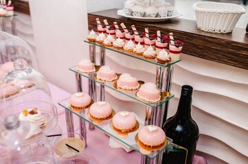 Sweet table. A plates of cakes and muffins with cream. Table with sweets, candy, buffet. Dessert table for a party goodies for the wedding. Close up. candy bar. Decorated delicious.