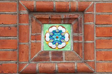 Colorfull green blue glazed tile in red brick wall
