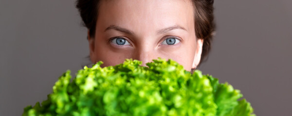 Young adult beautiful caucasian happy smiling woman portrait holding green fresh lettuce salad...