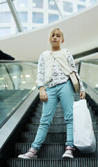 Fashion 9 years old girl with packages in shopping center