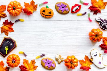 Frame of Halloween pumpkins, cookies and candies, top view