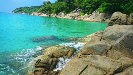 Freedom Beach in Patong, Phuket, Thailand view from the rocks on the beautiful sea and azure water.