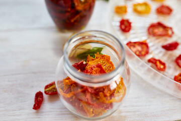 Homemade sun dried tomatoes with herbs, garlic in olive oil in a glass jar