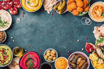 Traditional Middle Eastern assorted meze: hummus, pita, olives, pistachios, dolma, falafel balls,...