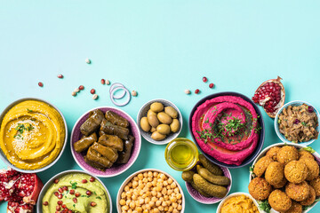 Mediterranean appetizer concept. Arabic traditional cuisine. Middle Eastern meze with pita, olives, hummus, stuffed dolma, falafel balls, pickles, babaganush, vegetables, pomegranate, eggplants