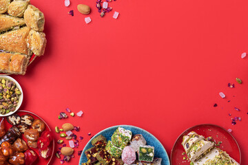 Traditional turkish delight on red background. Top view. Flat lay. Copy space. Arab dessert, baklava, halva, rahat lokum, sherbet, nuts, pistachios, dates, raisins, dried apricots, churchkhela.