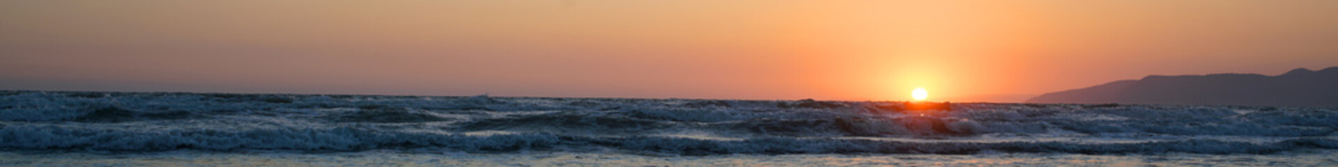 spacious panoramic shot of beautiful sea view with calm water waves and yellow sun ball on sunset