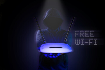 A hacker is holding a Wi-Fi router on a black background.