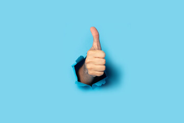 Male hand makes a hand up gesture on a blue background. Banner. Gesture all ok, like