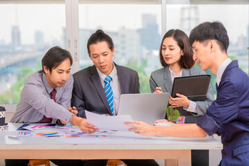 Successful Asian professionals looking through online ideas for their business project.