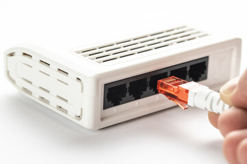 A white utp cable with a red convector is inserted into the white switch.