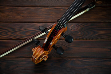 The cello lies on a wooden surface with a bow. Place for text