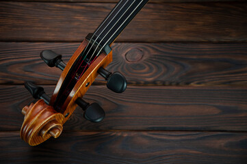 A fragment of a cello lies on a wooden surface. Place for text