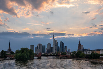 Fototapeta na wymiar Evening sunset panorama of skyscrapers of the business financial center of Frankfurt. Frankfurt stock market with colorful sunset rays clouds. 