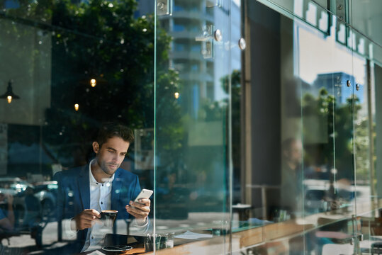 Businessman checking his cellphone messages in a cafe