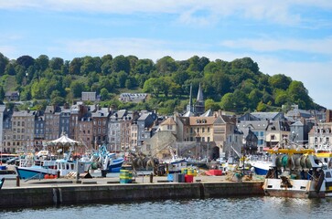 Fototapeta na wymiar Panoramic view from quayside to the the old port (Le Vieux Bassin) of the town Honfleur in the county of Calvados in Normandy, France, hilly landscape in the background, a sunny day in summer
