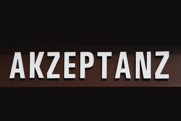 german word Akzeptanz - Acceptability - on dark background. concept of esteem and ensure societal acceptance, fighting against racism, prejudice, discrimination and racialism
