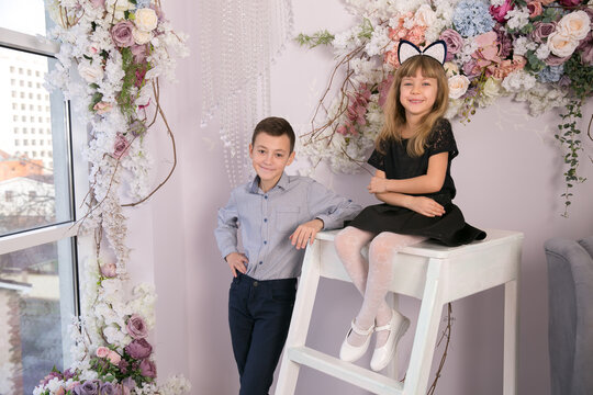 Fashionable brother and sister. Girl and boy in beautiful interior