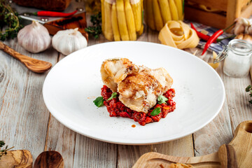 Fried white fish with vegetables stew in red sauce