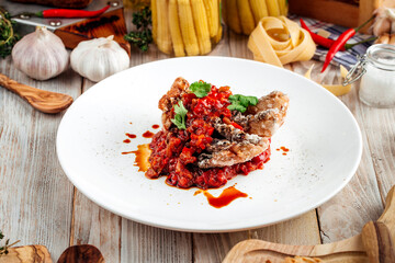 Fried white fish with vegetables stew in red sauce