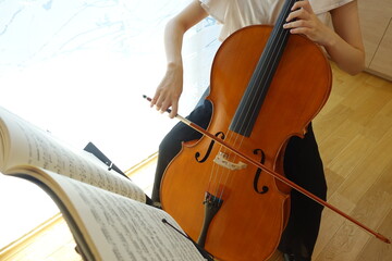 チェロを弾く女性　穏やかな光が射す部屋で　young woman playing the cello © kesuku