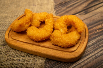 Atlantic prawns fried in batter on a wooden serving Board. Close up.