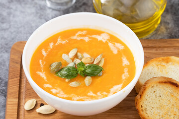 Pumpkin cream soup with seeds on a stone background