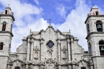 Fototapeta premium The facade of Havana Cathedral in Cuba. The sky is blue with some clouds.