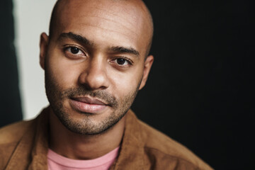 Fototapeta premium Image of pleased african american guy looking at camera