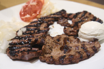 Traditional dish from Bosnian cuisine - grilled veal liver served with fresh onion, vegetables and rustic kackavalj cheese