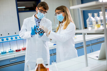 Young chemists holds molecular model in the lab