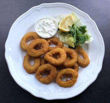 Crispy deep fried Calamari with sauce tartare. Fried squid rings is a seafood appetizer.