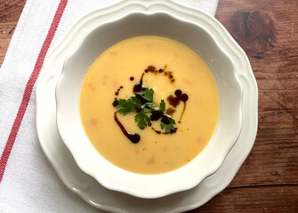 Creamy pumpkin soup with pumpkin pieces and a few drops of pumpkin seed oil.