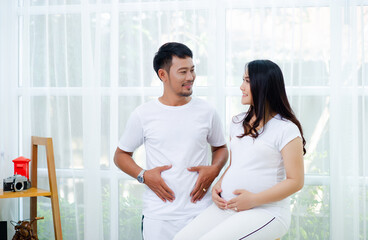 Fototapeta premium The pregnant woman is happy with her husband, preparing to watch the child who is about to give birth.