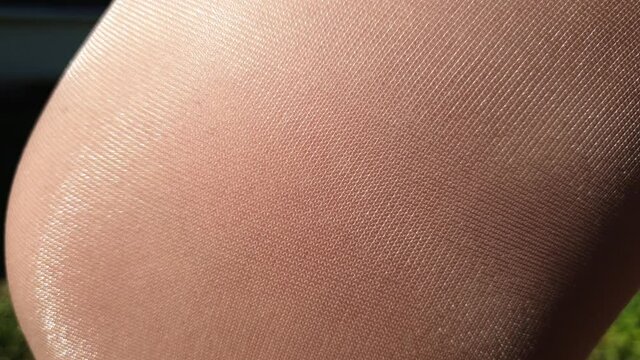 shiny thin beige tights, women's leg in nylon pantyhose
