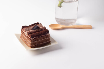 The chocolate cake is layered in a plate on a white background.