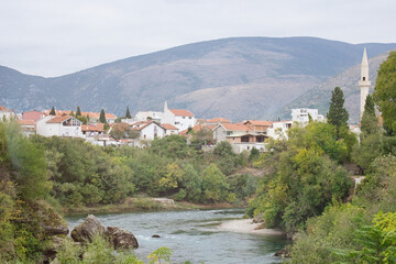 The historic town of Mostar, spanning a deep valley of the Neretva River, is famous for Old Bridge,...