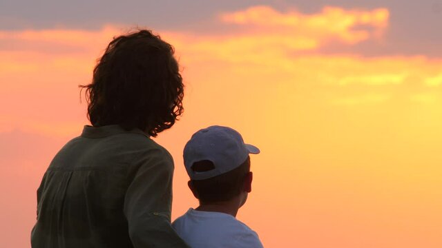 Rear view of mother and son at sunrise. Interpersonal relationship. Interpersonal communication. One parent family. Loving mother spends time with child. Psychology concept. Native people. Friendship