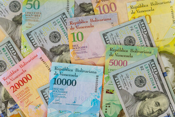 Fototapeta na wymiar Hundred US dollars banknotes and banknote with different paper bills currency Venezuelan Bolivar