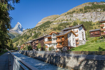 Fototapeta na wymiar Zermatt with river Mattervispa, Matterhorn and typical houses in summer, Switzerland