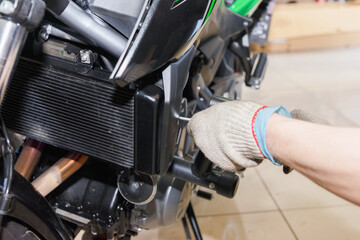 Fototapeta premium The master performs maintenance on the motorcycle.